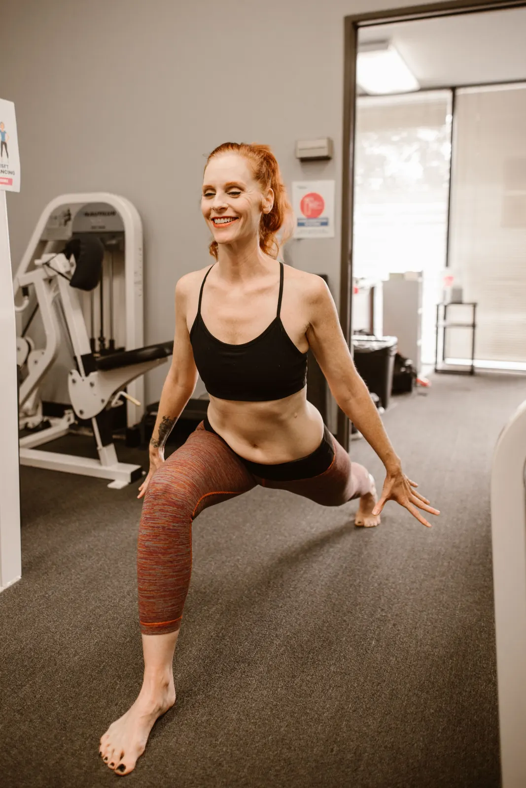 A woman doing a deep stretch barefoot at home