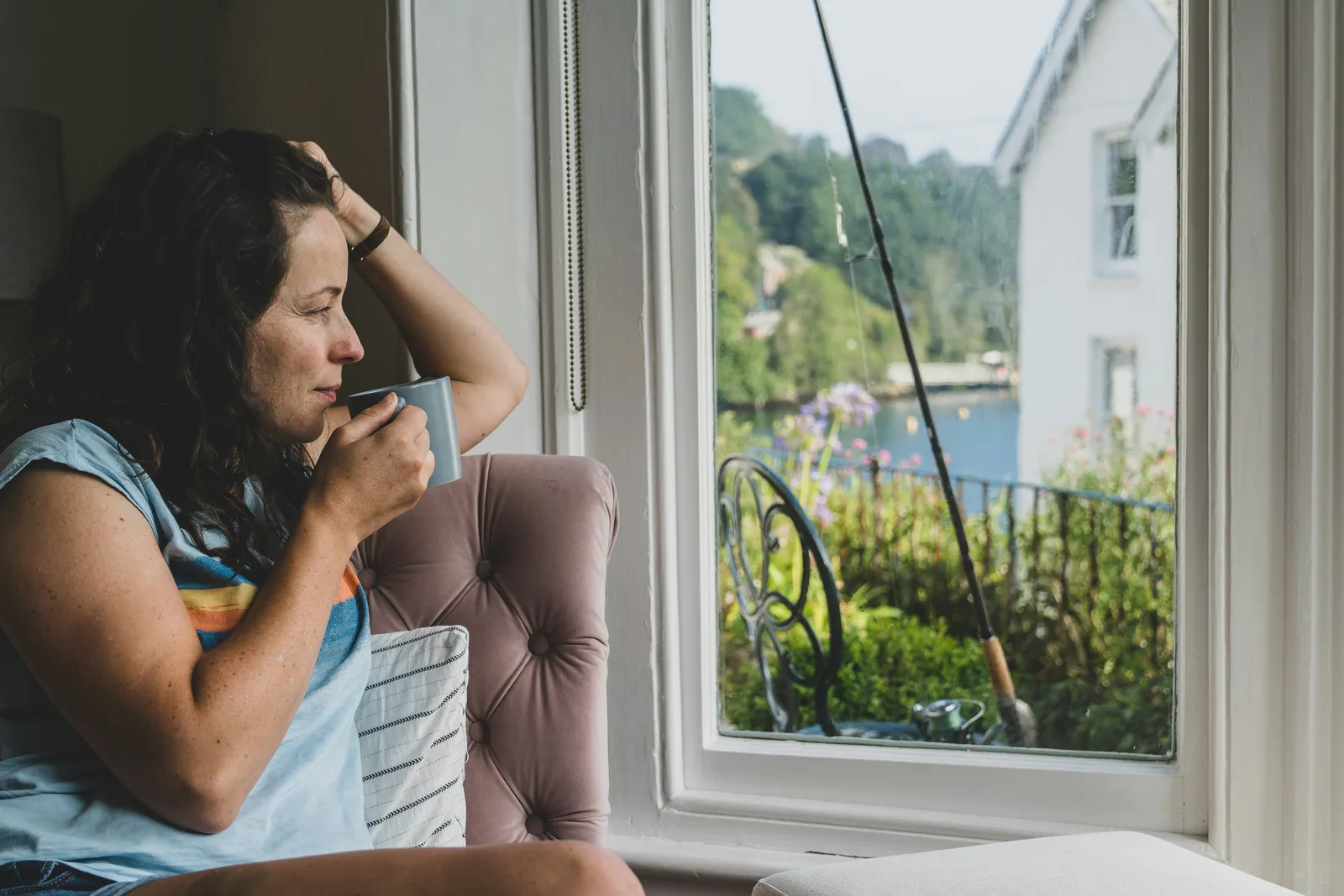 A woman with a morning drink at a window