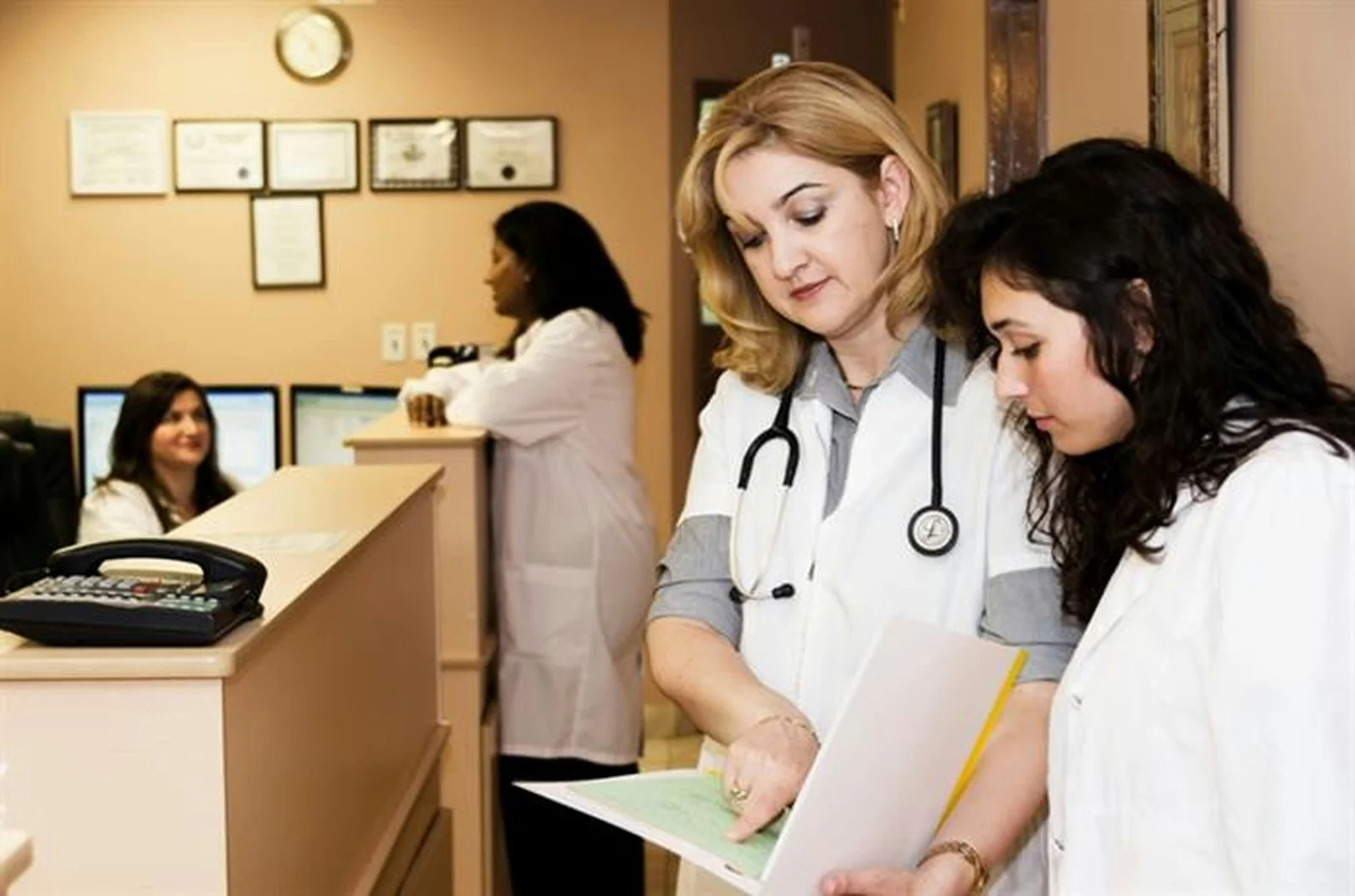 Clinicians reviewing a chart at a front desk